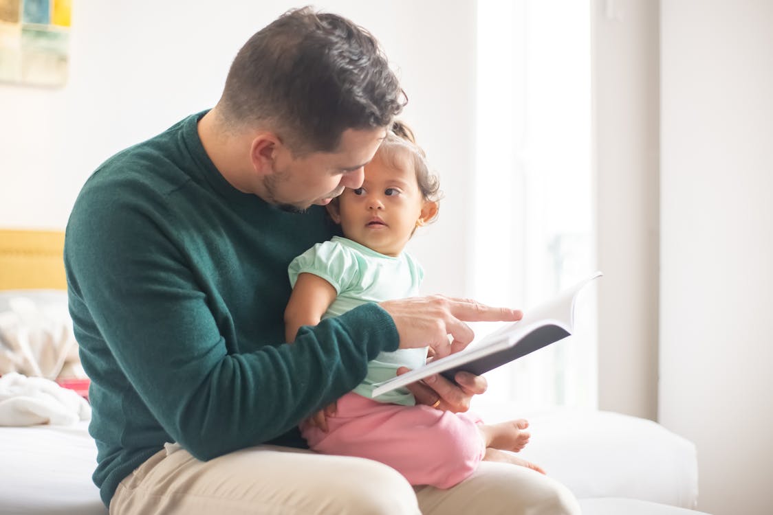 Free stock photo of baby, baby in arms, book reading Stock Photo
