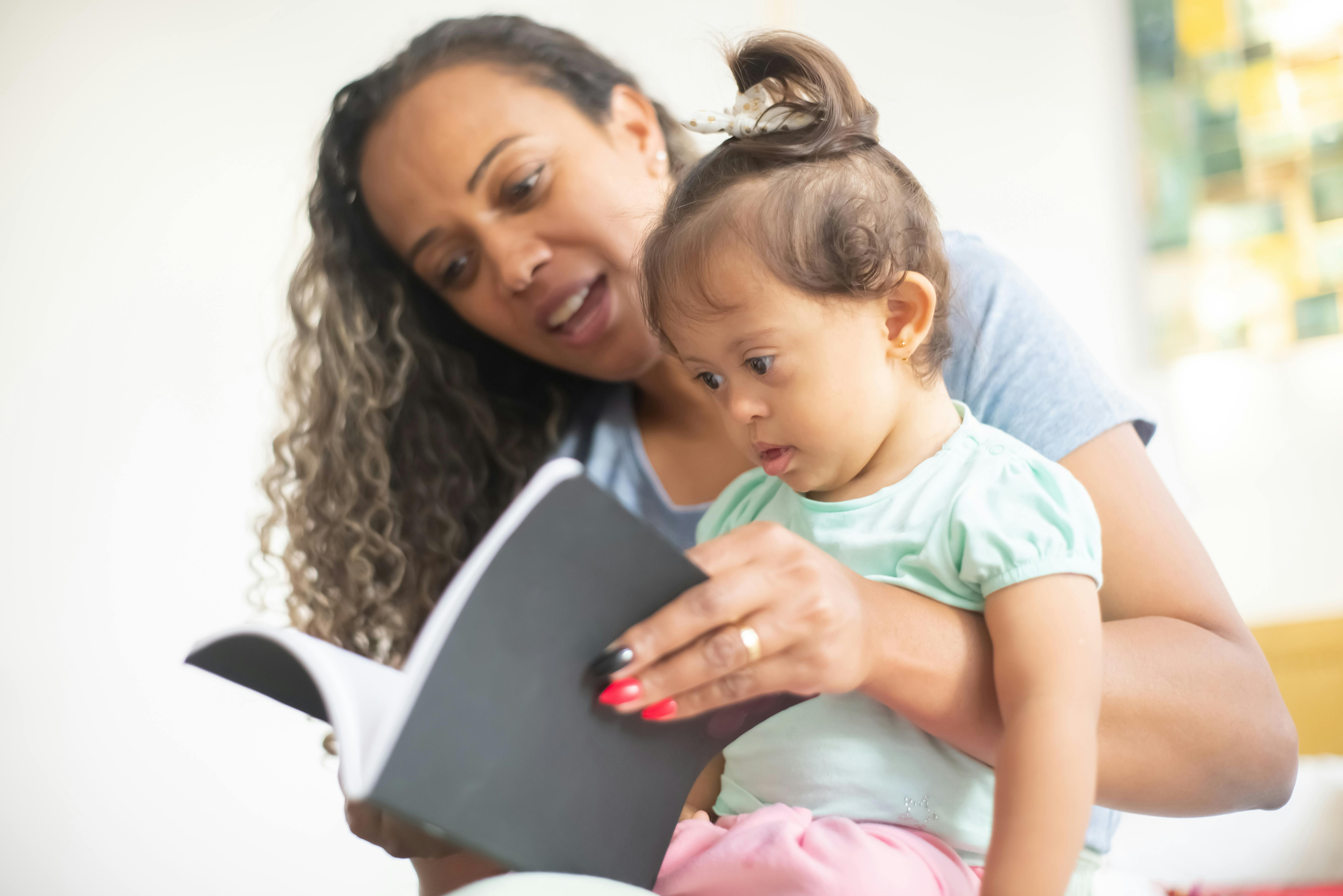 mother and baby girl reading the book together