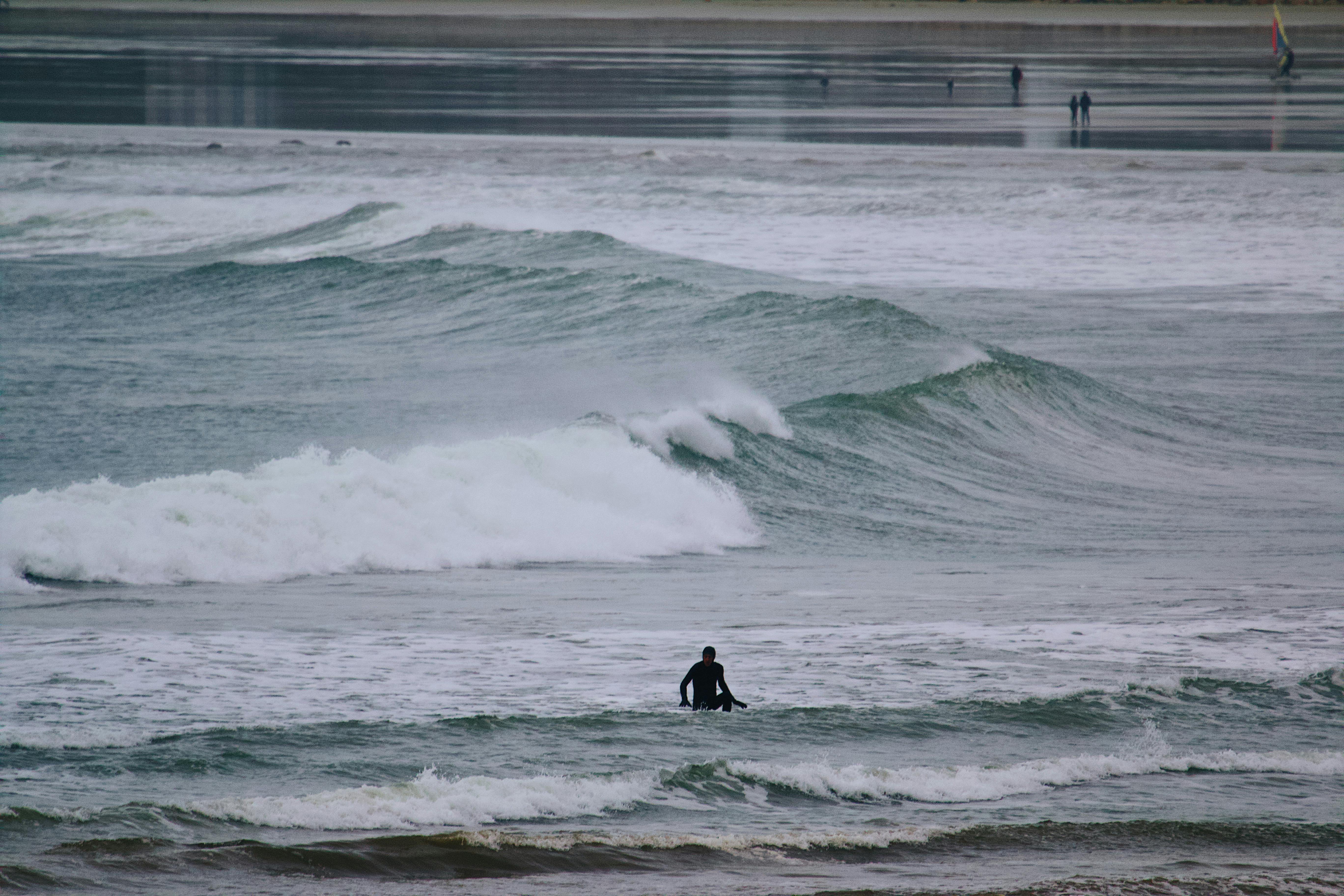 Surfer in winter conditions paddling out during cold water session