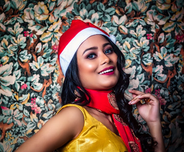 A Woman Wearing A Santa Hat And A Red Scarf