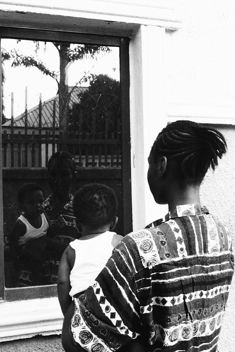 Child And Parent Looking At Window