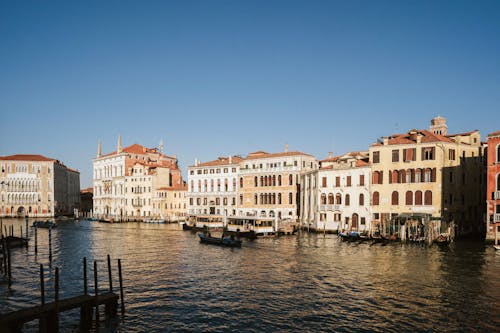 White and Brown Concrete Buildings Beside Body of Water