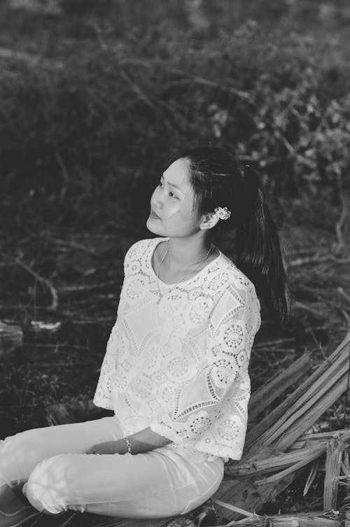 A Grayscale Photo of a Woman Wearing A Lacey Top