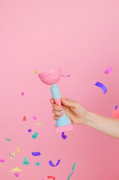Celebrate success with a colorful trophy and vibrant confetti on a pink background.