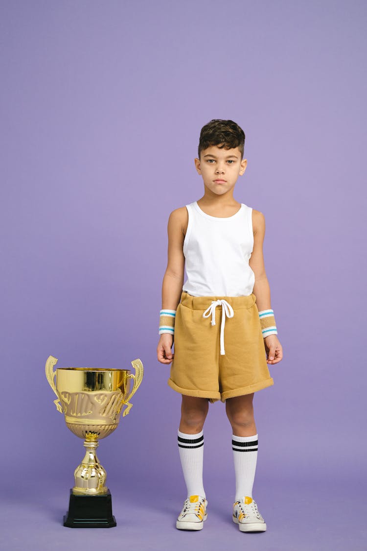 A Boy Winning A Gold Trophy