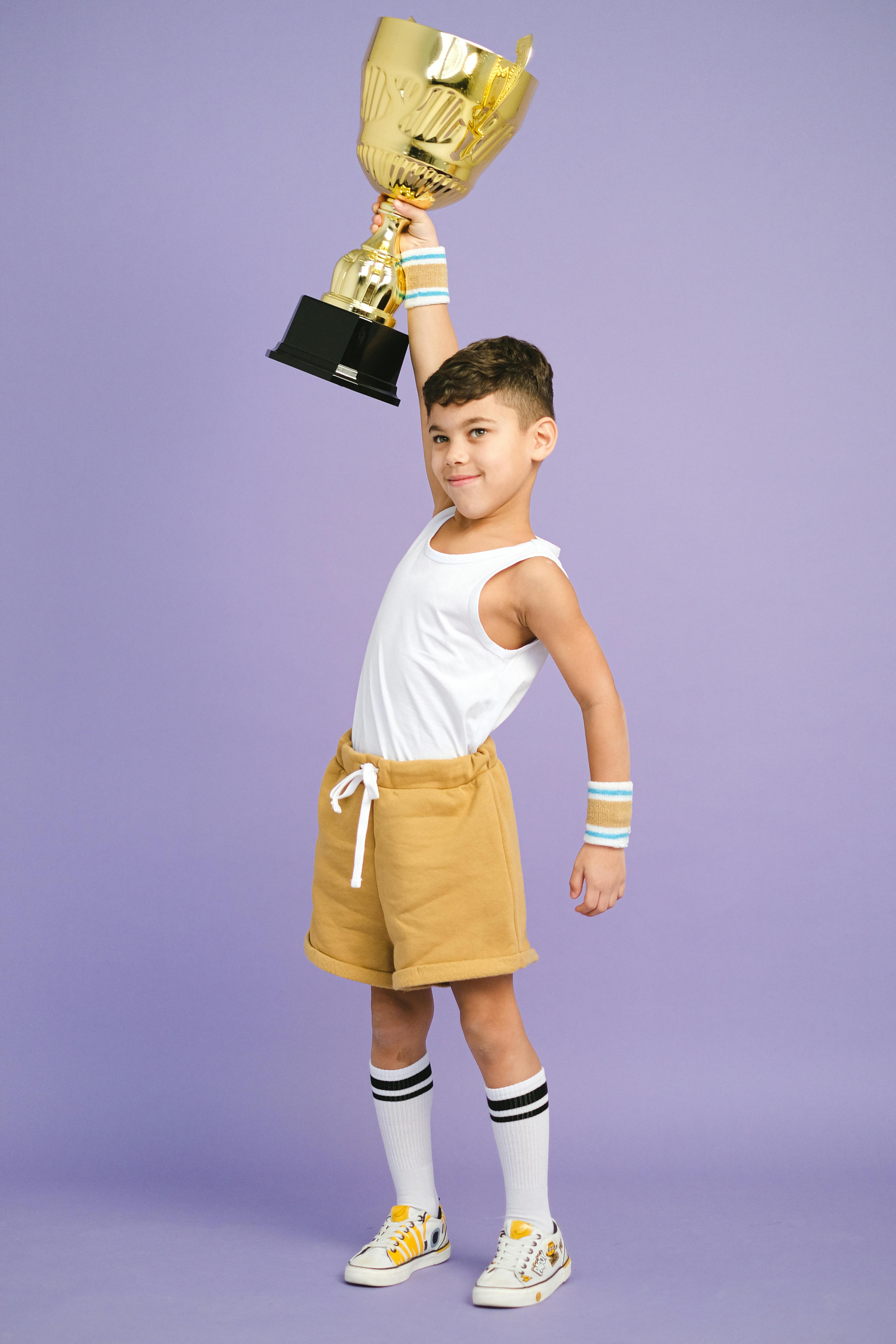 a boy winning a gold trophy