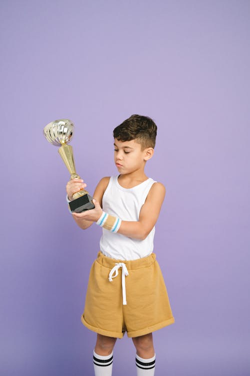 Free A Boy Holding a Trophy Stock Photo