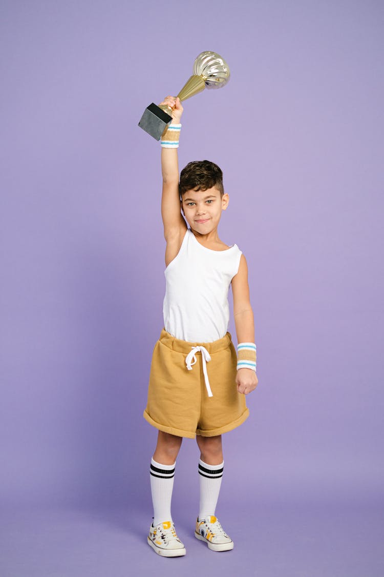 Boy In White Tank Top Holding A Trophy