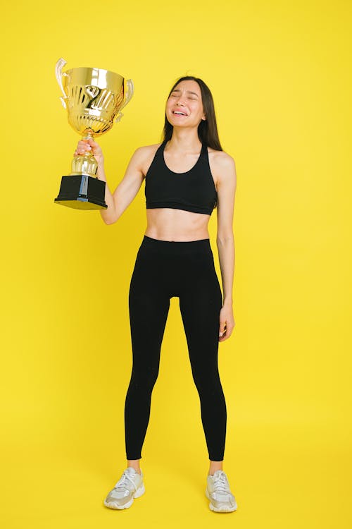 Woman Wearing Sportswear Holding a Trophy