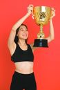 Woman in Black Sports Bra and White Shorts Holding Gold Trophy