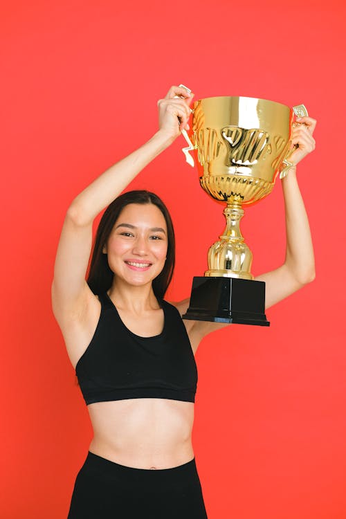 Free Woman in a Black Sports Bra Holding a Trophy Stock Photo