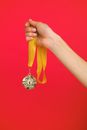 Person Holding Yellow Strap With Silver Round Pendant