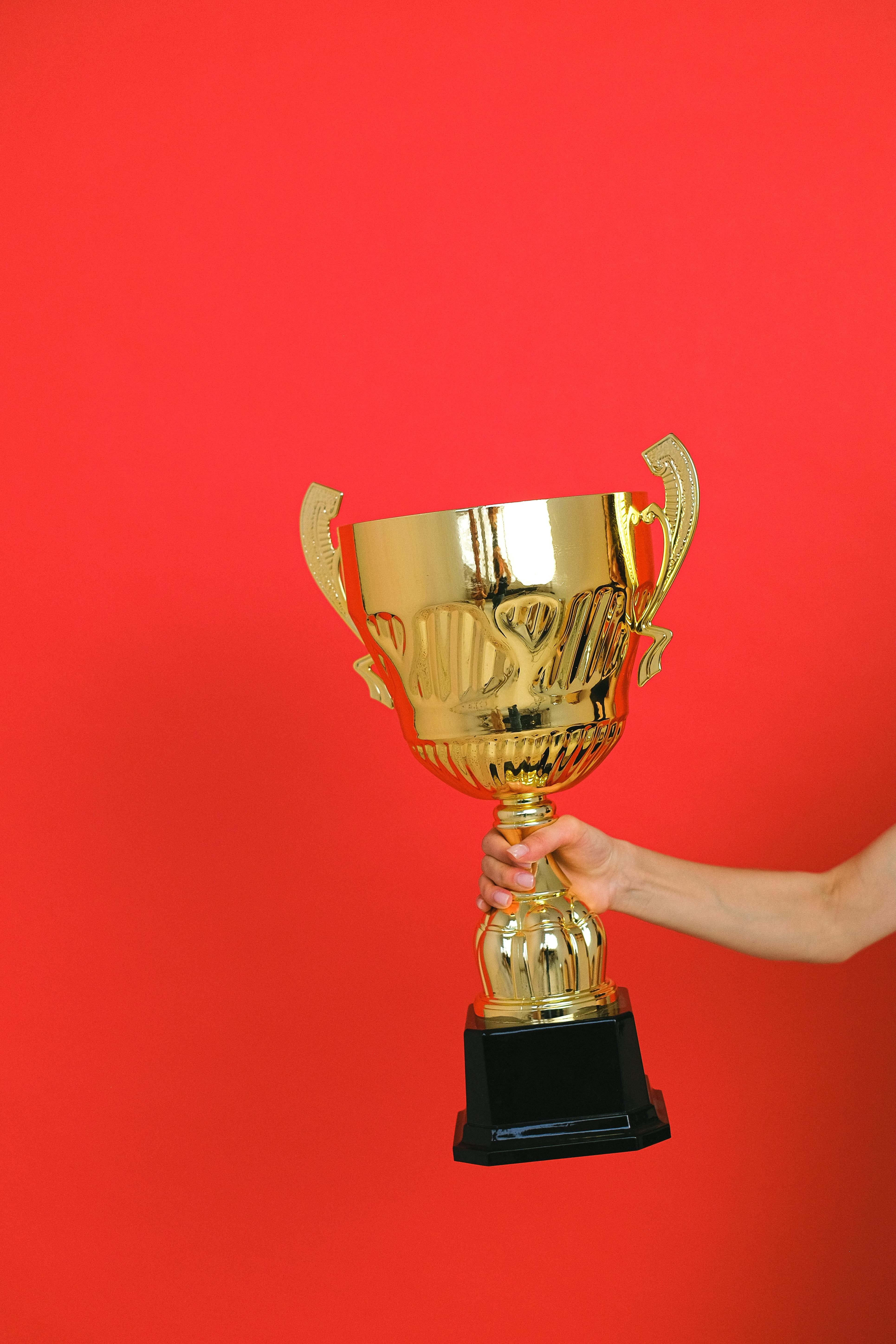 close up shot of a person holding a gold trophy