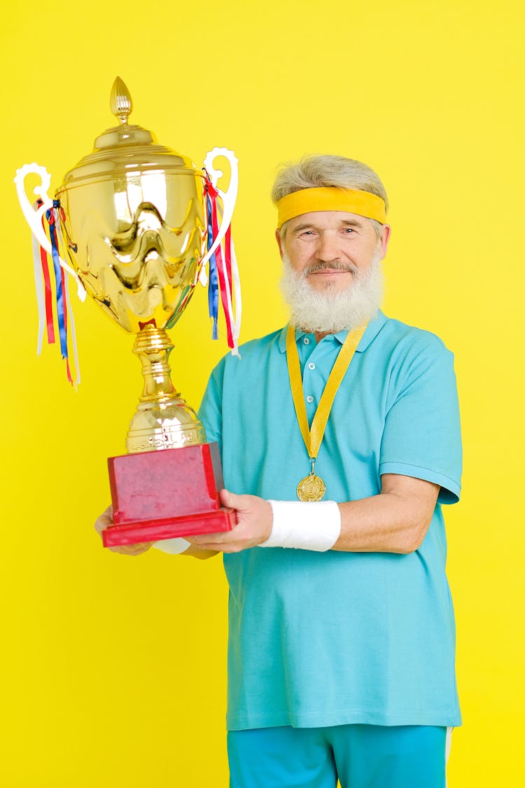 An Elderly Man Winning A Gold Trophy