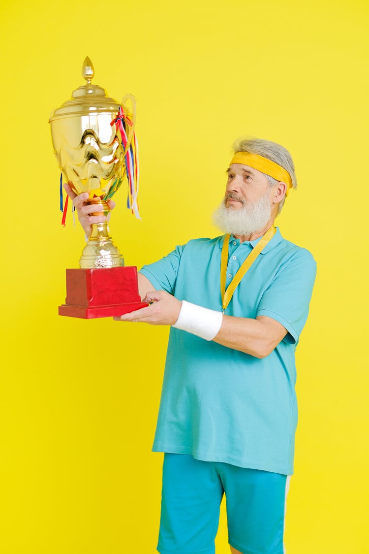 An Elderly Man Winning A Gold Trophy