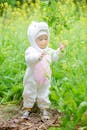 Child in Pink and White Onesie Standing beside Green Plants