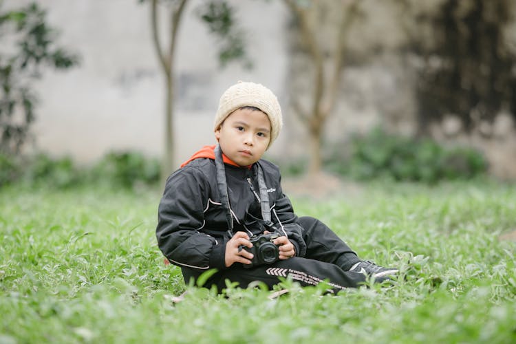 A Boy Holding A Camera