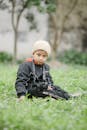 An Adorable Boy Sitting on the Grass