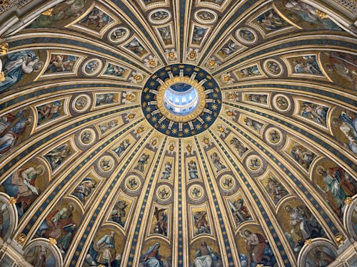 From below amazing dome ceiling with ornamental fresco paintings and stucco elements in St Peters Basilica in Rome
