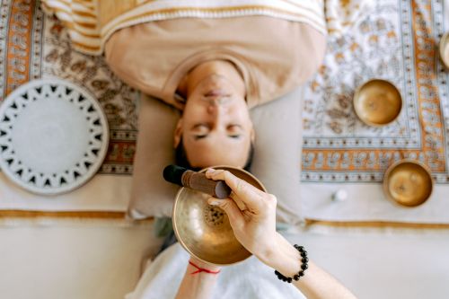 Free A man experiencing deep relaxation during a sound therapy session with Tibetan singing bowls for holistic wellness. Stock Photo