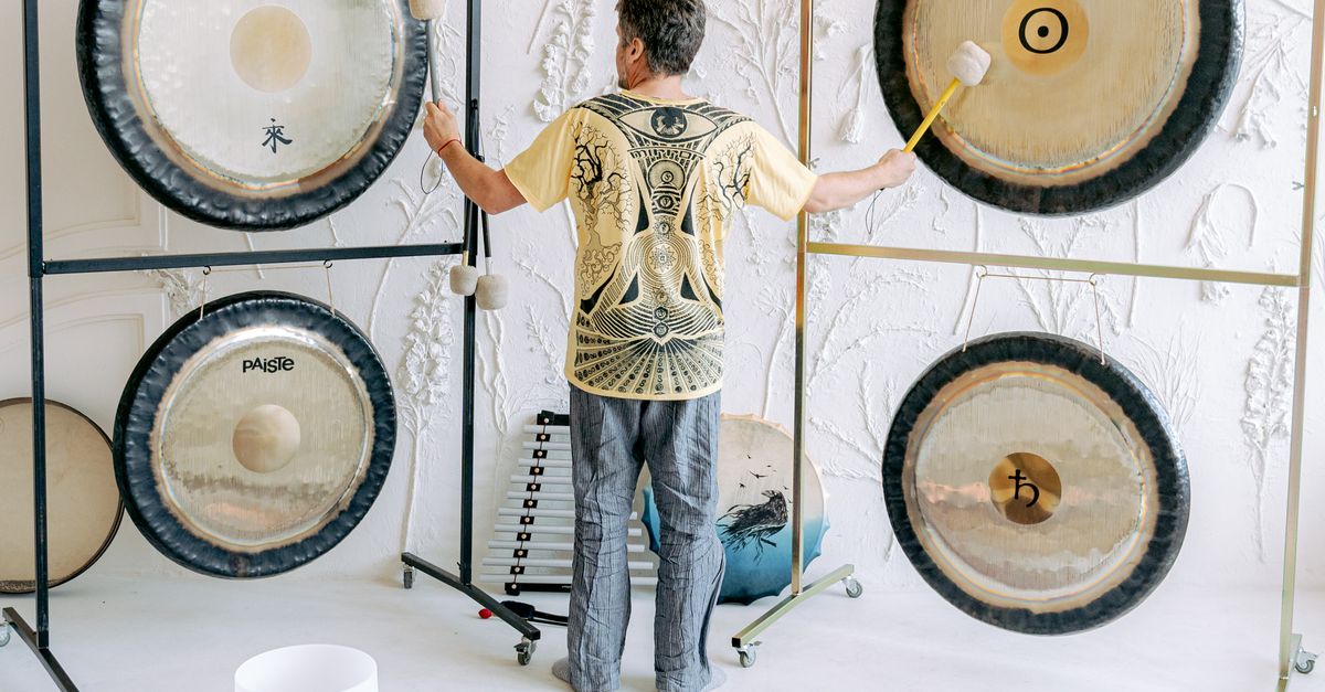 Man Ringing Gong A Man Standing while Playing Gongs · Free Stock Photo