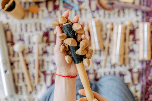 Detailed view of a hand gripping a traditional percussion instrument with a textured background.