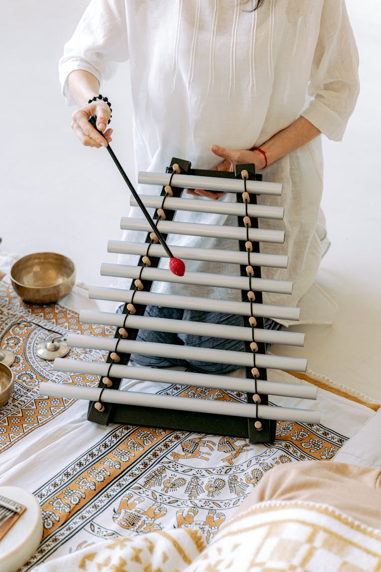 Person In White Top Playing A Xylophone