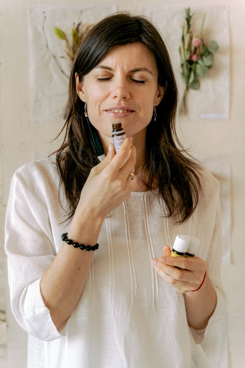 Free A serene woman smelling essential oil, emphasizing relaxation and wellness in a peaceful setting. Stock Photo