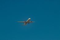 Large airplane flying in blue cloudless sky