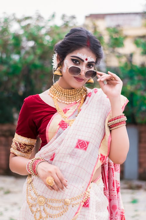 Free Portrait of a Woman in a Sari Dress Touching Her Sunglasses Stock Photo