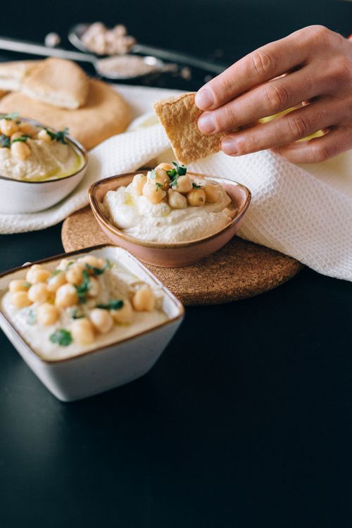 Free Close-up of hummus garnished with chickpeas, served with pita bread. Stock Photo
