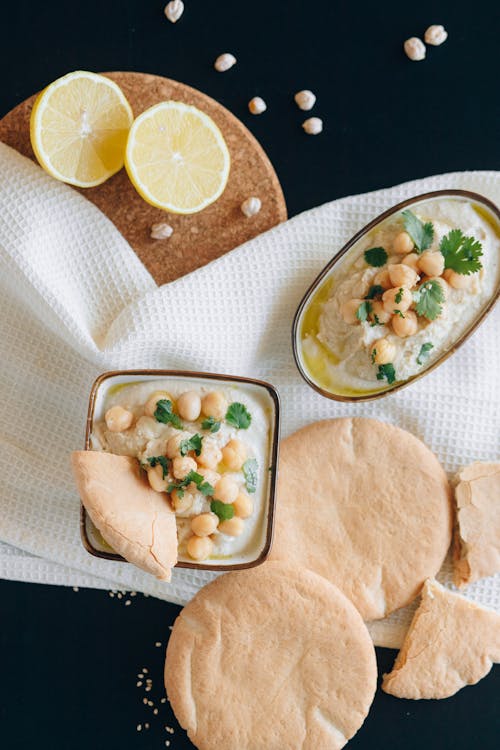 Free Overhead Shot of a Sliced Lemon Near Hummus Stock Photo