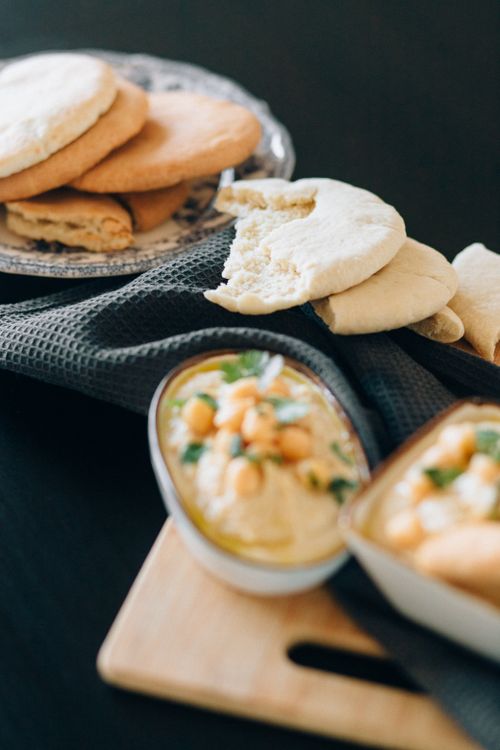 Free Delicious Mediterranean hummus with fresh pita bread served on a chopping board, perfect for appetizers. Stock Photo
