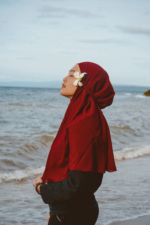 Tranquil ethnic female enjoying freedom on seashore