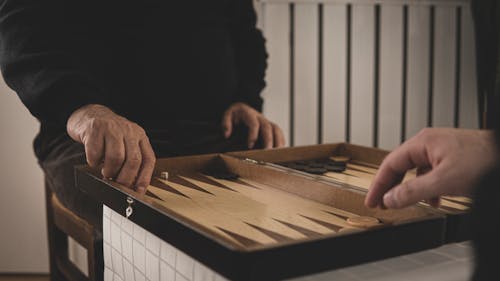 Close-Up Shot of Person Playing Backgammon