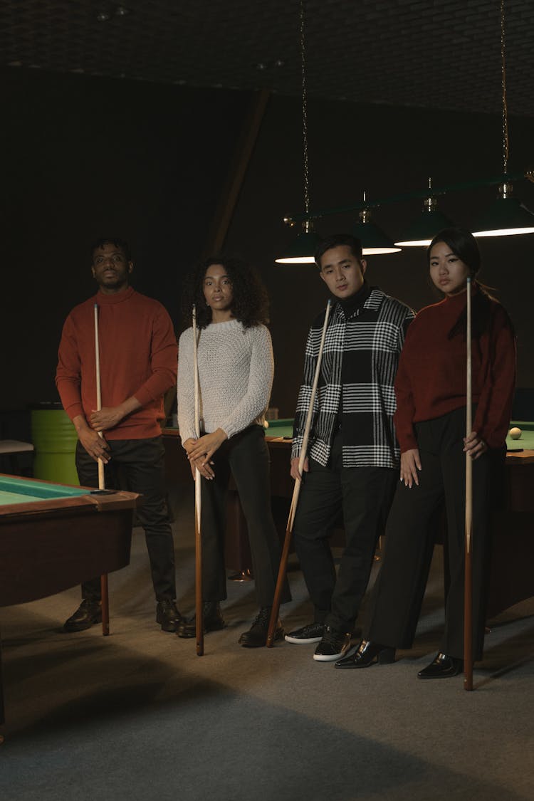 Billiard Players Standing And Holding A Cue Sticks