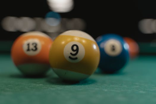 Focused shot of billiard balls 9 and 13 with blurred background, highlighting sporting detail.