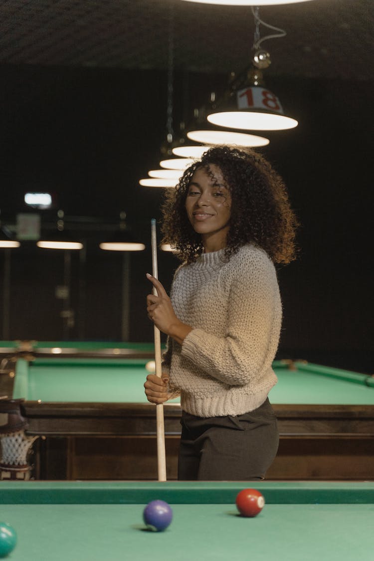 Woman In A Knitted Sweater Holding A Cue Stick