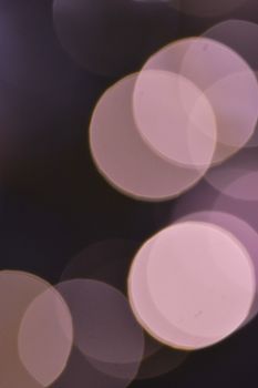 Abstract creative background with bright bokeh and abundance of round vivid blurred pink spots of light glowing on black background