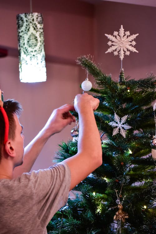 Anonymous man decorating Christmas tree