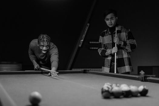 Two men focus intently as they play pool, enjoying a competitive game indoors.