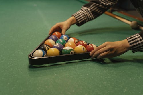 Person Setting Billiard Balls Using a Rack