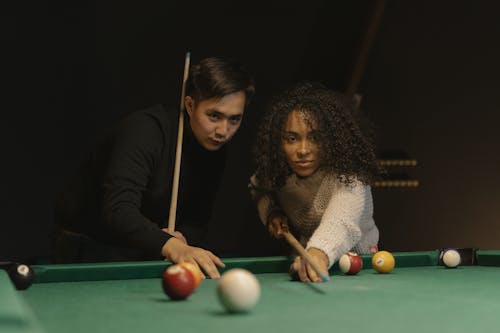 Close-Up Shot of a Man and a Woman Playing Billiards