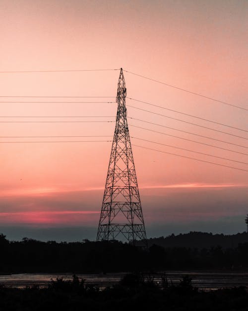 A Tall Electric Tower During Sunset