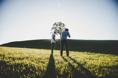 Two Men Standing on Green Grass