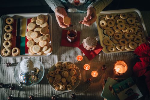 Free A cozy holiday scene featuring homemade cookies, candles, and festive decorations. Stock Photo