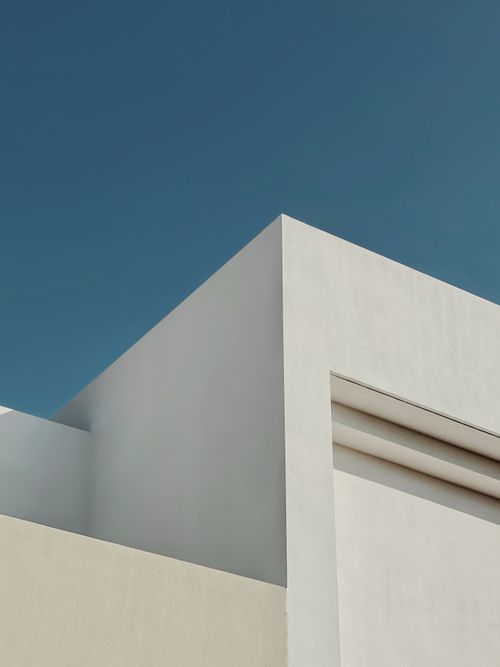 Free Part of roof of white modern house with geometric design located on street against clear blue sky on sunny day Stock Photo