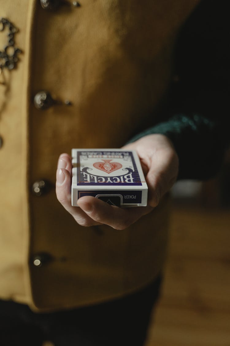 A Person Holding A Sealed Box Of Playing Cards