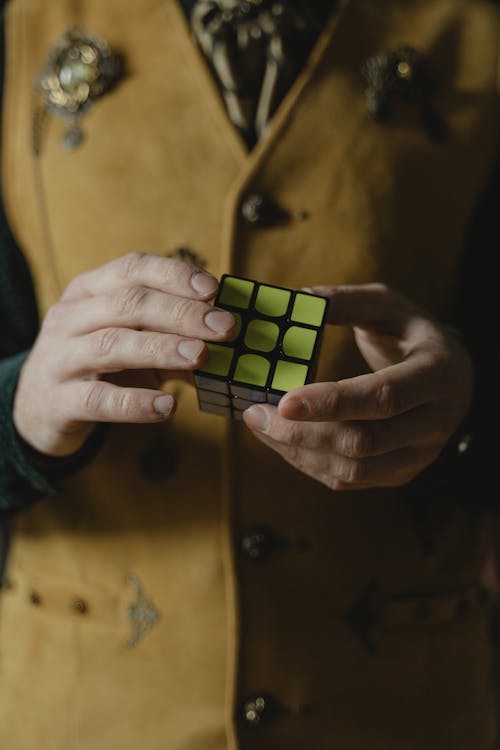 Photo of a Person's Hands Holding a Solved Rubik's Cube