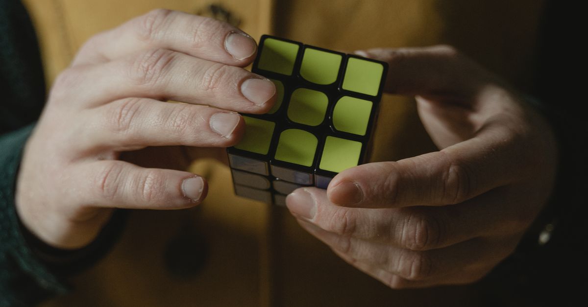Photo of a Person's Hands Holding a Solved Rubik's Cube · Free Stock Photo